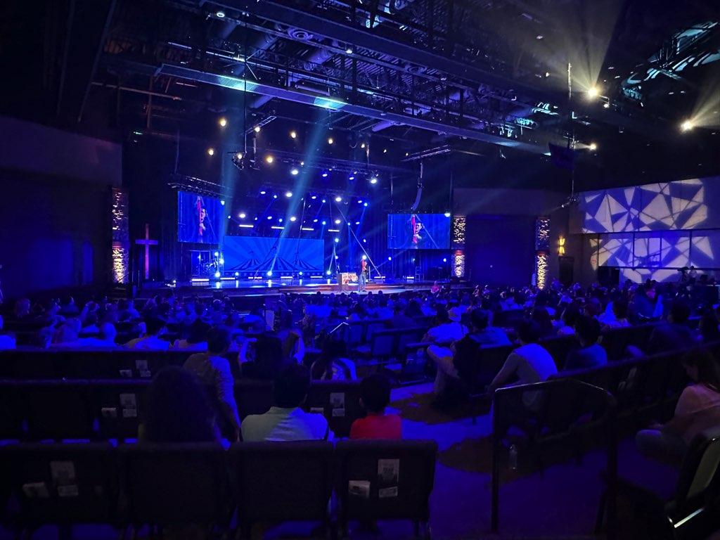 Evan performing on stage, photographed from the back of the theater
