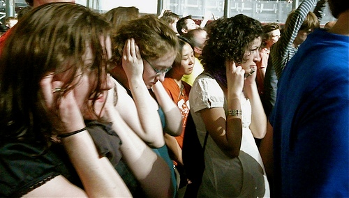Crowd holding their ears